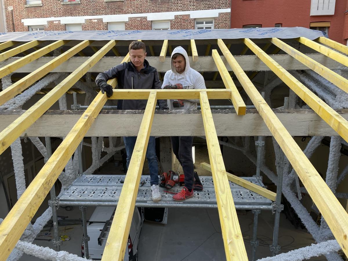 Charpente en bois en cours de pose, chevrons et pannes en place
